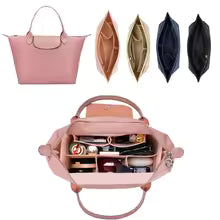 Pink handbag with compartments and makeup items on a white background