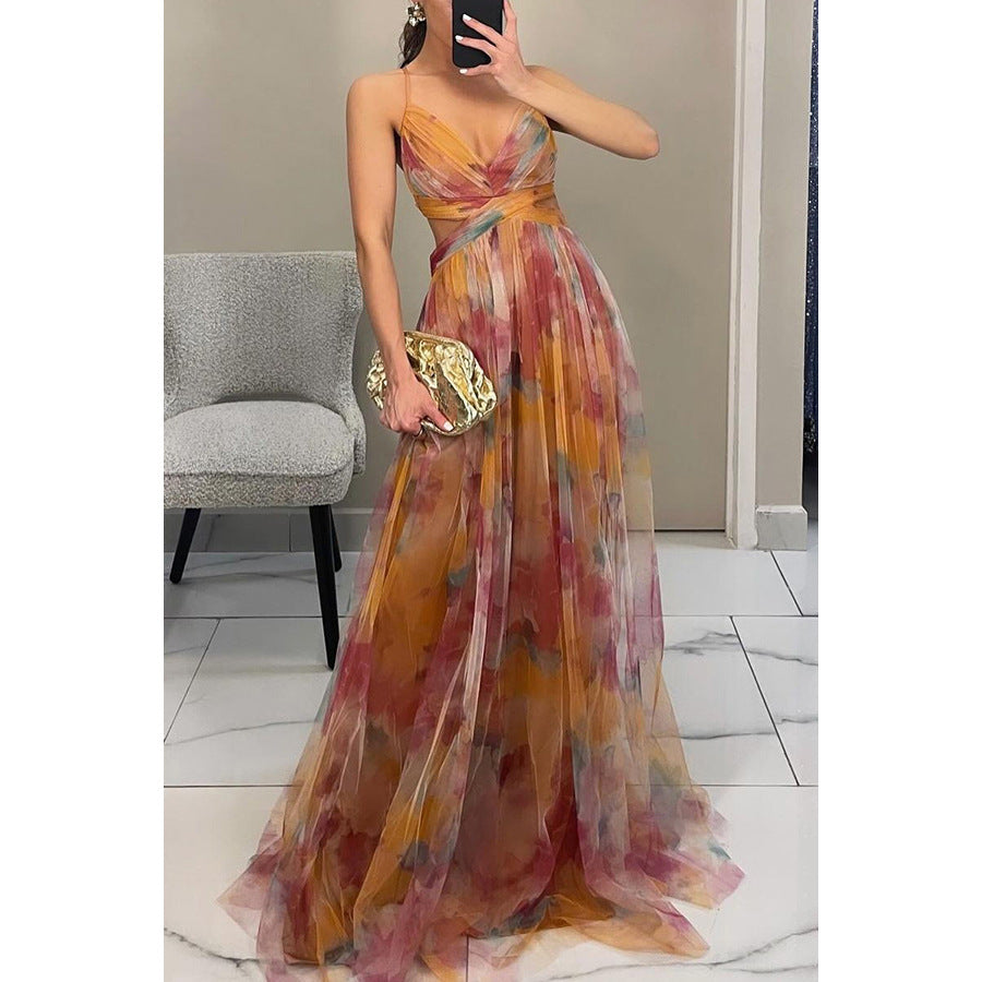 Woman in a colorful evening gown taking a mirror selfie in a room.