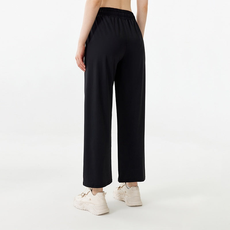Person wearing black wide-leg pants on a white background