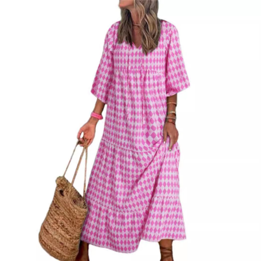Woman wearing a pink checkered dress holding a woven bag on a white background