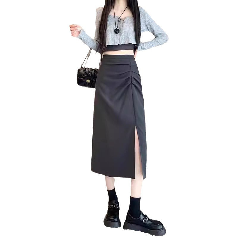 Person wearing a gray top and black skirt with a black handbag on a white background
