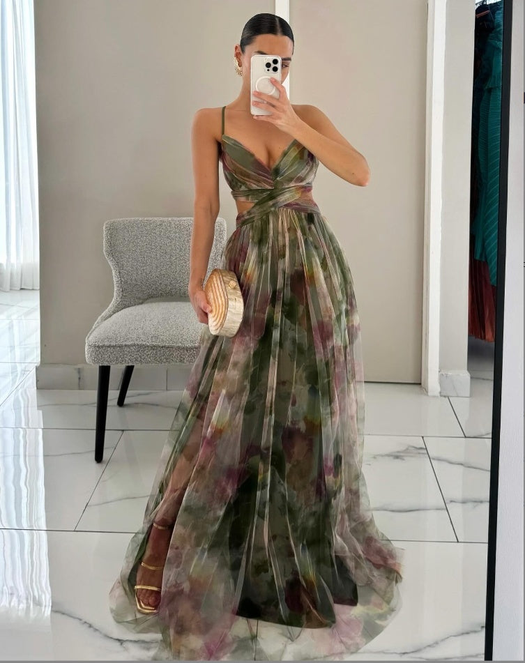 Woman in a floral dress taking a mirror selfie in an indoor setting.
