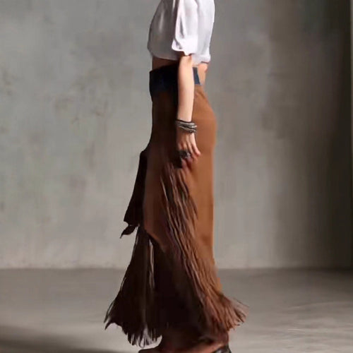 Person wearing a brown fringed skirt with a plain background