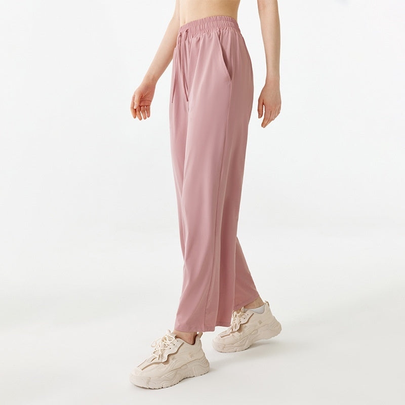 Person wearing pink pants and white sneakers on a white background