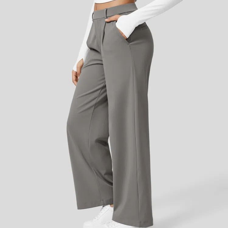 Brown wide-leg pants worn with a white top on a light gray background