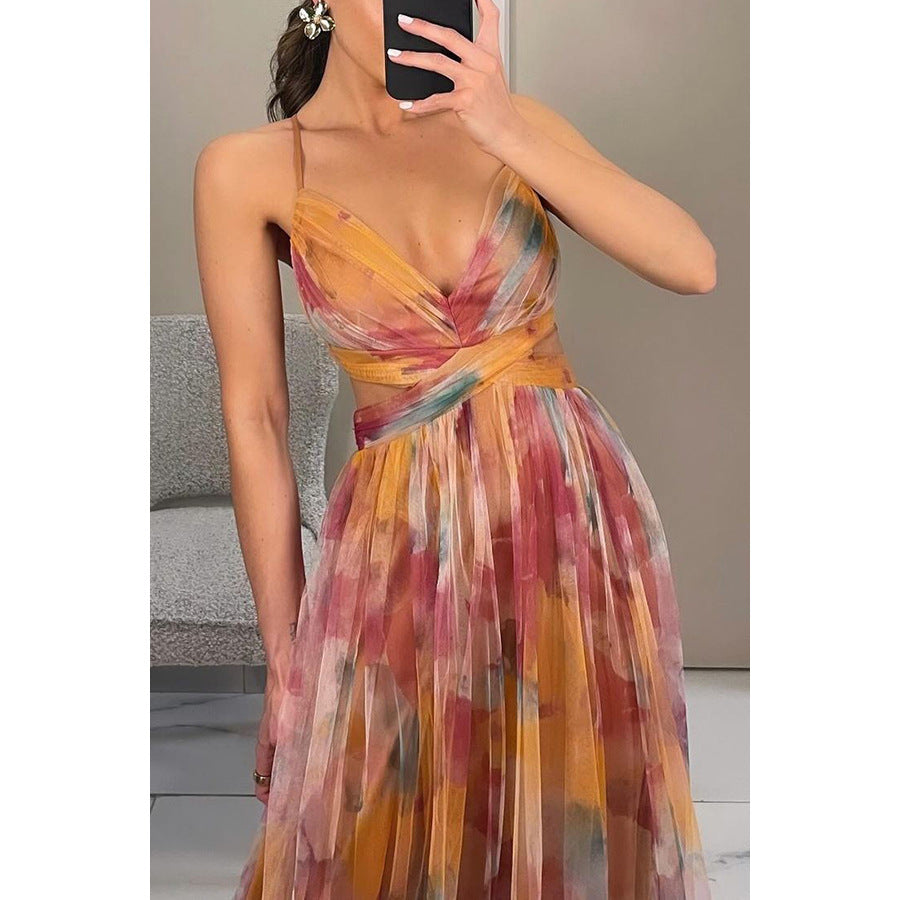 Woman wearing a colorful one-shoulder dress taking a mirror selfie.