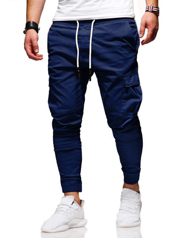 Navy blue jogger pants worn by a person on a white background