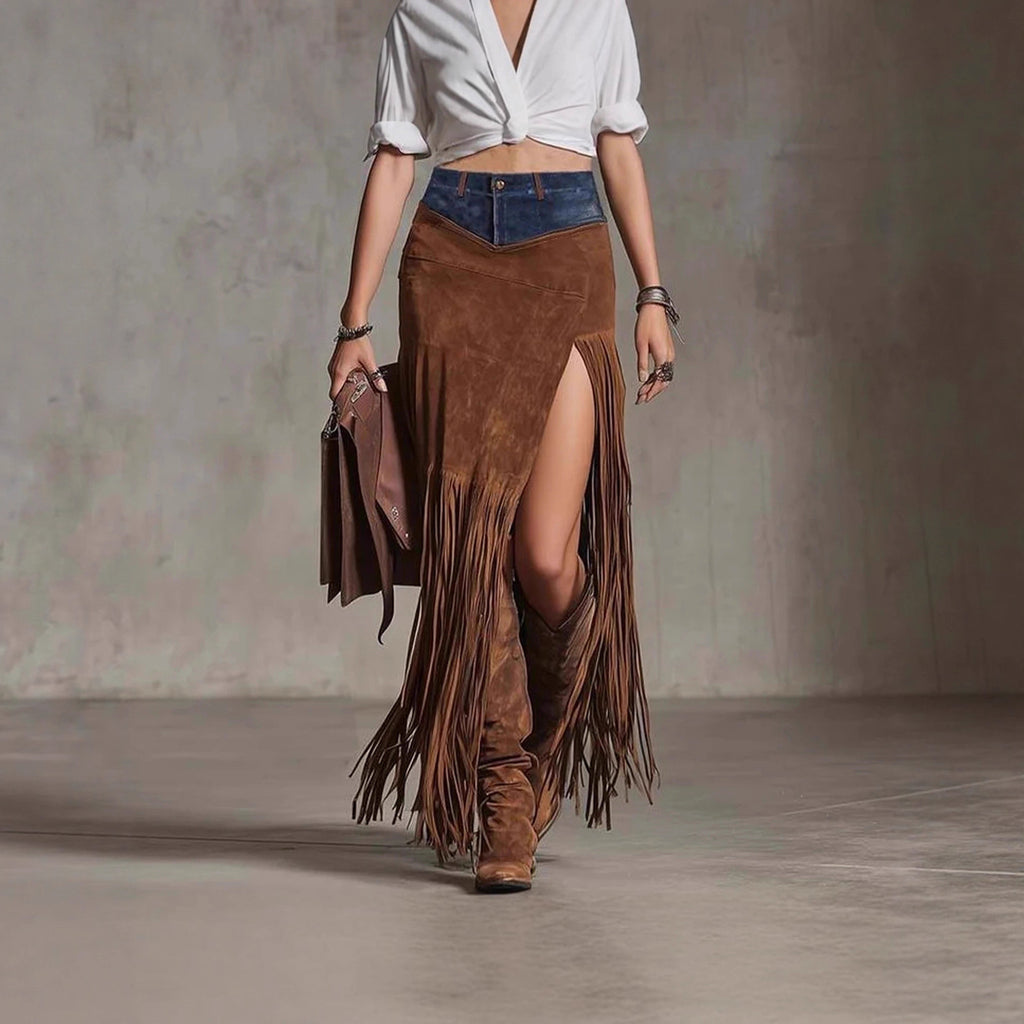 Person wearing a white top, blue denim skirt, and brown suede fringe skirt with boots against a neutral background.